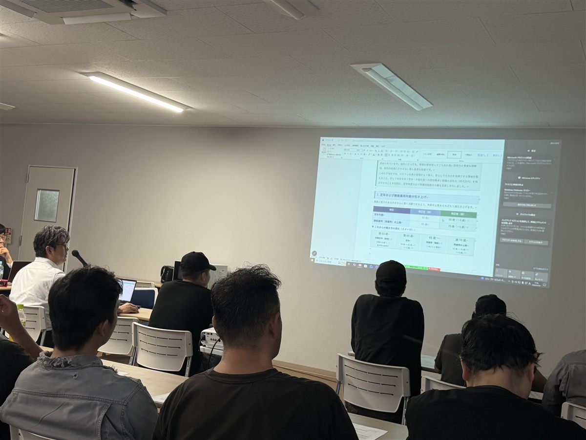 スクリーンで定年・再雇用の引き上げを説明